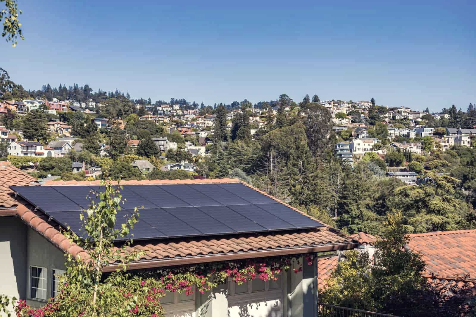 Solar collector panels mounted on a residential roof in low afternoon light